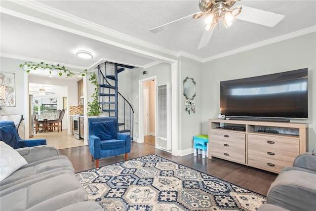living room with crown molding, a heating unit, stairs, and ceiling fan