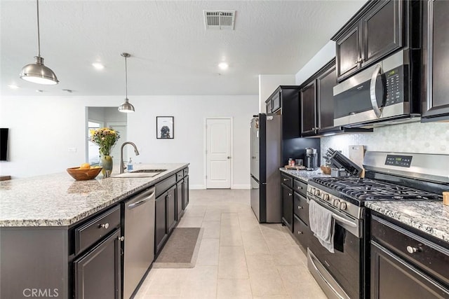 1628 N Delbert Ave, Fresno, CA 93722 - kitchen with a sink, a center island with sink, visible vents, light stone counters, and appliances with stainless steel finishes