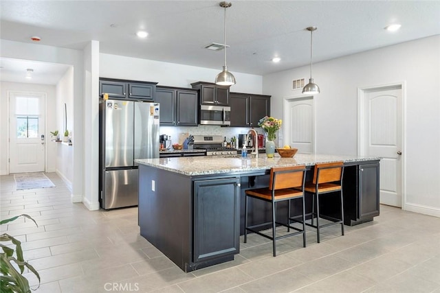 1628 N Delbert Ave, Fresno, CA 93722 - kitchen with a kitchen breakfast bar, light stone counters, a large island with sink, a sink, and appliances with stainless steel finishes