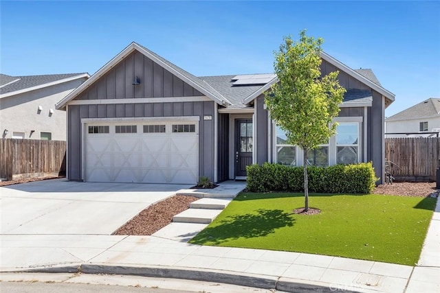 1628 N Delbert Ave, Fresno, CA 93722 - view of front facade with fence, solar panels, board and batten siding, driveway, and a garage