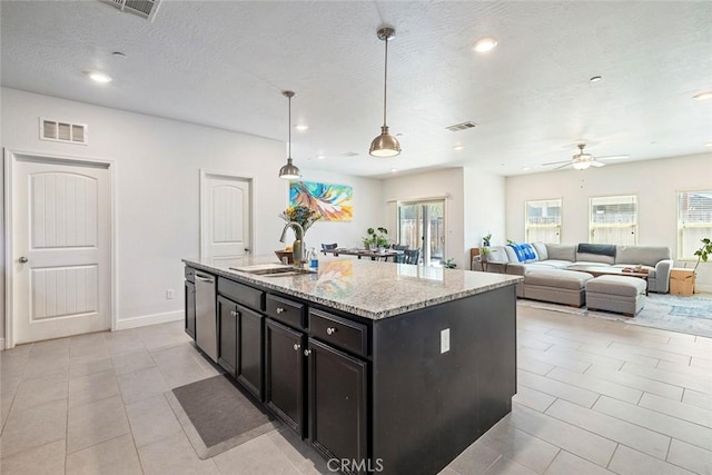 1628 N Delbert Ave, Fresno, CA 93722 - kitchen with light stone counters, visible vents, a ceiling fan, a sink, and a kitchen island with sink