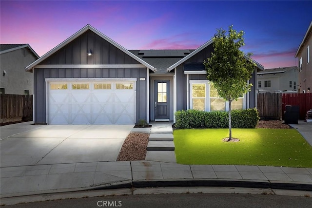 1628 N Delbert Ave, Fresno, CA 93722 - ranch-style house with solar panels, driveway, fence, an attached garage, and board and batten siding