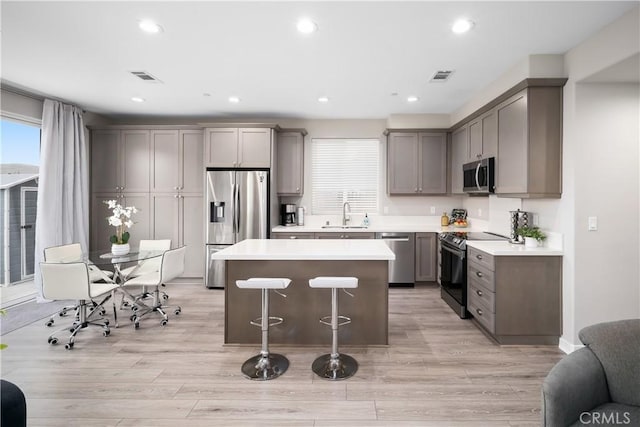 1866 Homestead Pl, San Luis Obispo, CA 93405 - kitchen with appliances with stainless steel finishes, gray cabinetry, a kitchen island, a kitchen breakfast bar, and light countertops