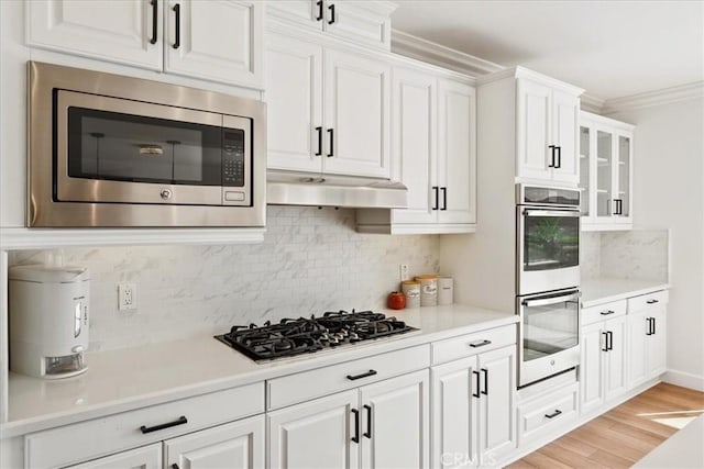 2836 Mesa Grove Rd, Fallbrook, CA 92028 - kitchen featuring appliances with stainless steel finishes, white cabinets, tasteful backsplash, light countertops, and light wood-style floors