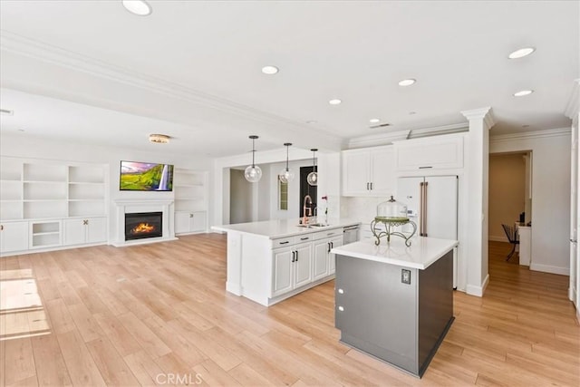 2836 Mesa Grove Rd, Fallbrook, CA 92028 - kitchen featuring a peninsula, crown molding, light countertops, open floor plan, and light wood-style floors