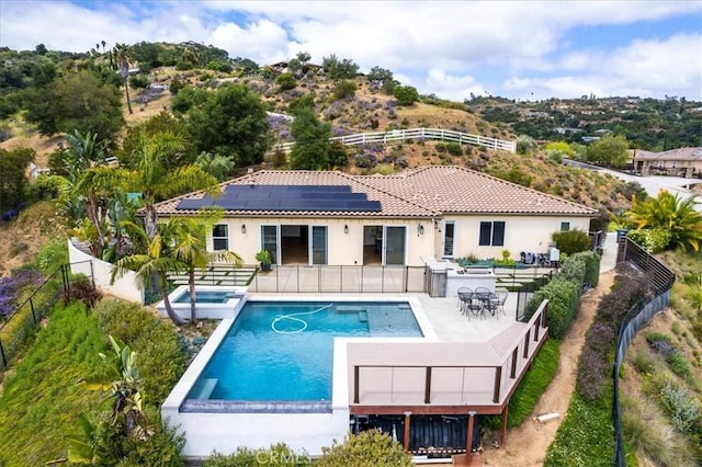 2836 Mesa Grove Rd, Fallbrook, CA 92028 - back of house featuring solar panels, a fenced backyard, a pool with connected hot tub, stucco siding, and a patio area
