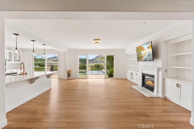 2836 Mesa Grove Rd, Fallbrook, CA 92028 - unfurnished living room with a glass covered fireplace, crown molding, light wood finished floors, and built in features