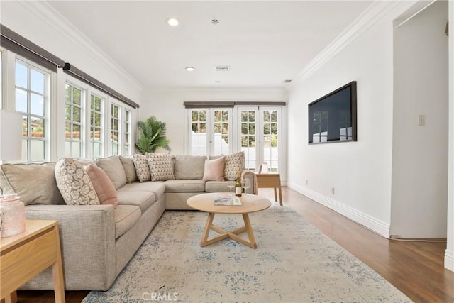 living area with wood finished floors, a wealth of natural light, and baseboards