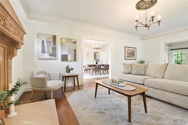 living room featuring wood finished floors, a notable chandelier, and ornamental molding