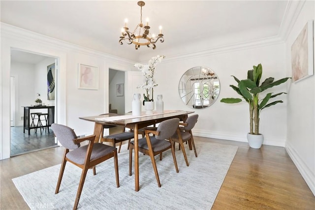 dining space featuring light wood finished floors, baseboards, and a notable chandelier