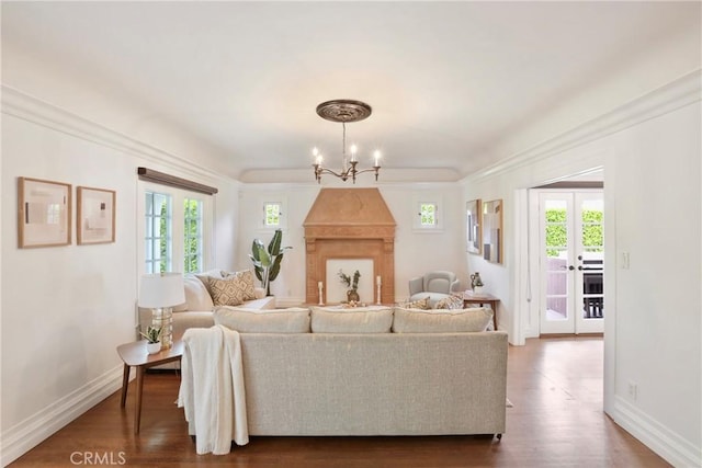 living room featuring baseboards, an inviting chandelier, dark wood-type flooring, and plenty of natural light