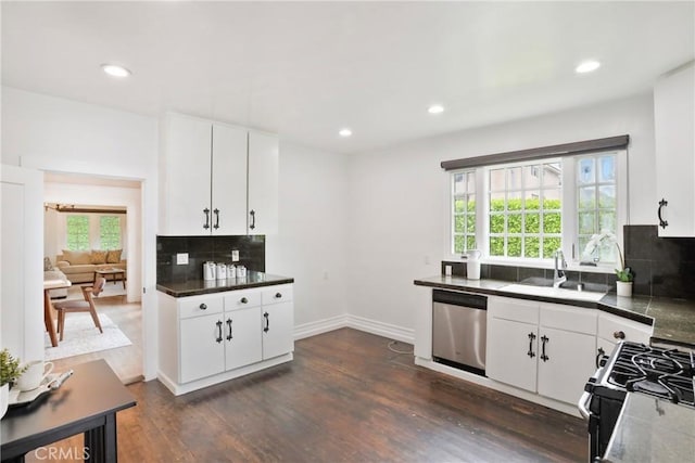 kitchen featuring dark countertops, dishwasher, a sink, gas stove, and decorative backsplash