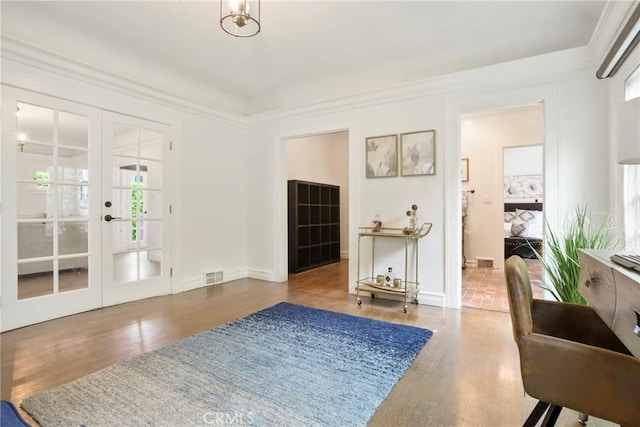 interior space featuring wood finished floors, baseboards, french doors, and visible vents