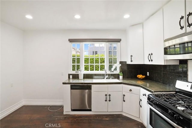 kitchen featuring dark wood finished floors, appliances with stainless steel finishes, a sink, and recessed lighting