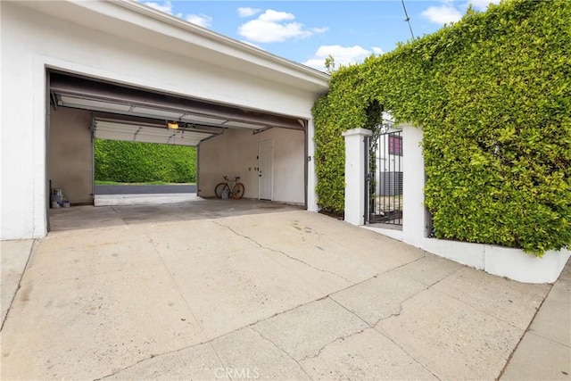 garage featuring driveway and a gate