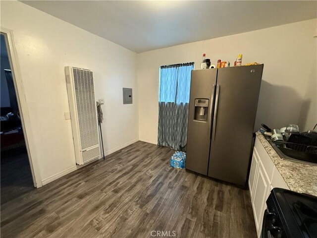 kitchen featuring a heating unit, electric panel, black range, dark wood finished floors, and stainless steel fridge with ice dispenser
