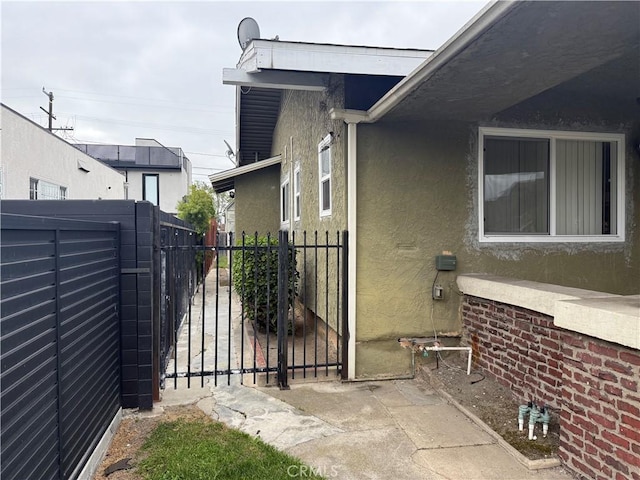 5442 6th Ave, Los Angeles, CA 90043 - view of side of home featuring stucco siding and a gate