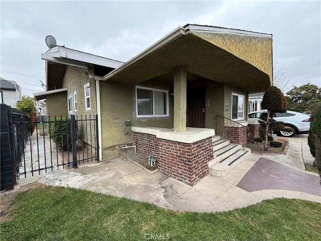 view of front of house featuring stucco siding and fence