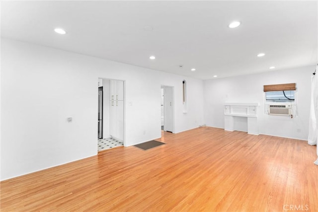 unfurnished living room featuring cooling unit, recessed lighting, and light wood-style floors
