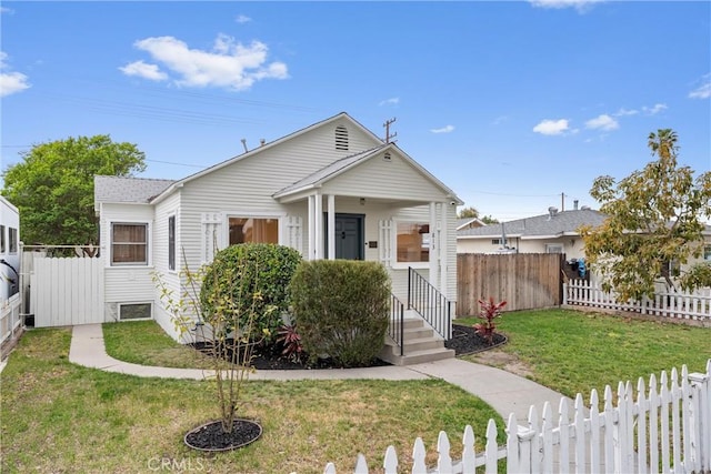 bungalow-style home featuring a fenced backyard and a front yard