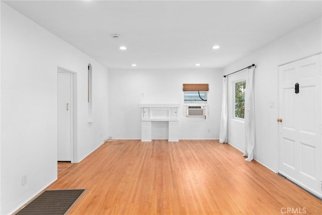 unfurnished living room with light wood finished floors, cooling unit, visible vents, and recessed lighting