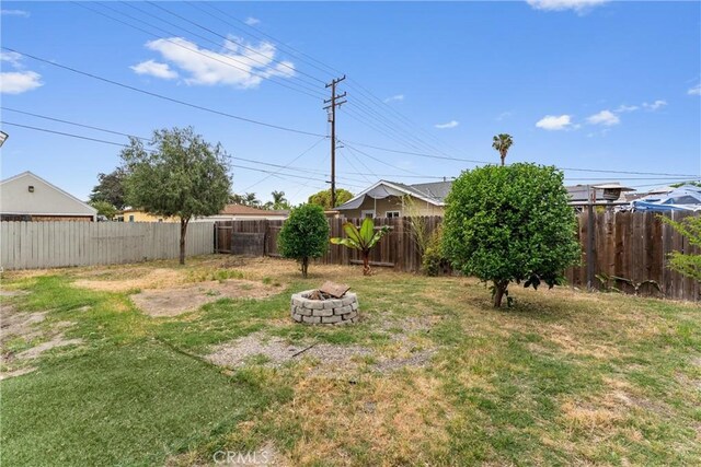 view of yard with a fenced backyard and an outdoor fire pit