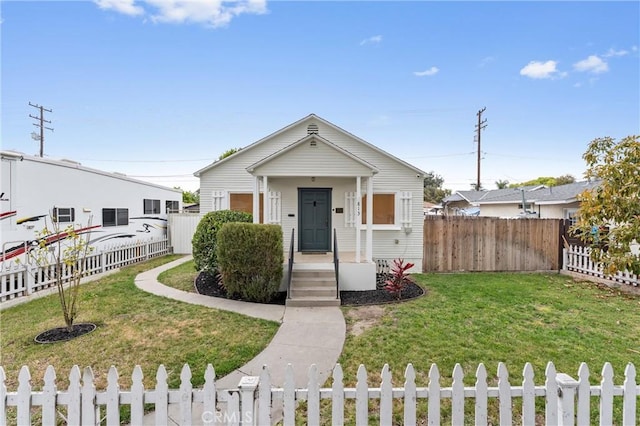 view of front facade featuring fence private yard and a front lawn