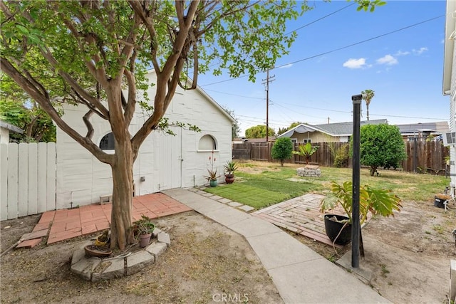 view of yard with a fire pit, a patio, and a fenced backyard