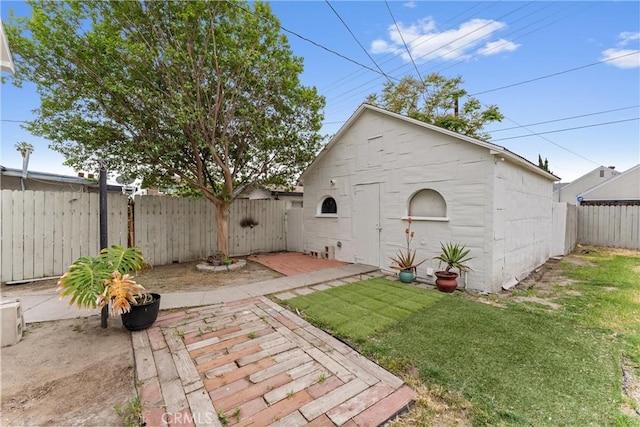 back of house with a fenced backyard, a gate, a patio, and a lawn
