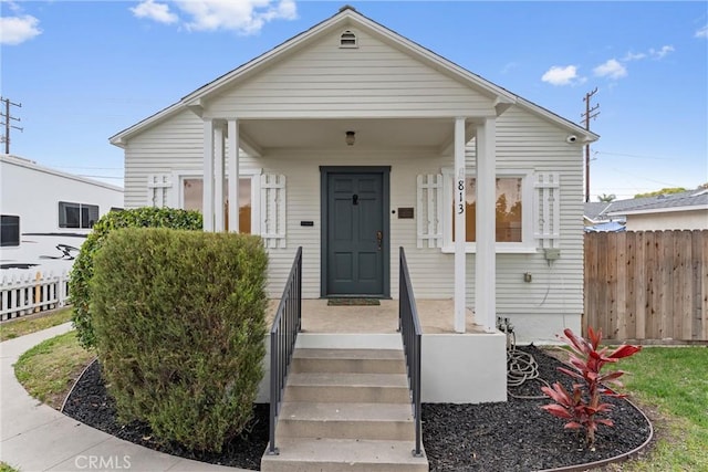 shotgun-style home with central AC and fence