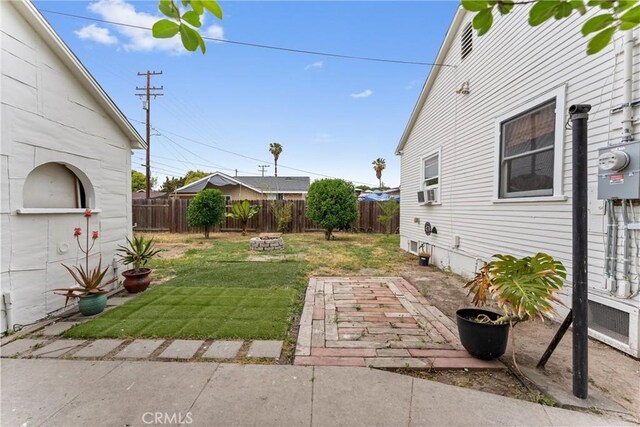 view of yard with a fire pit, a patio, and a fenced backyard