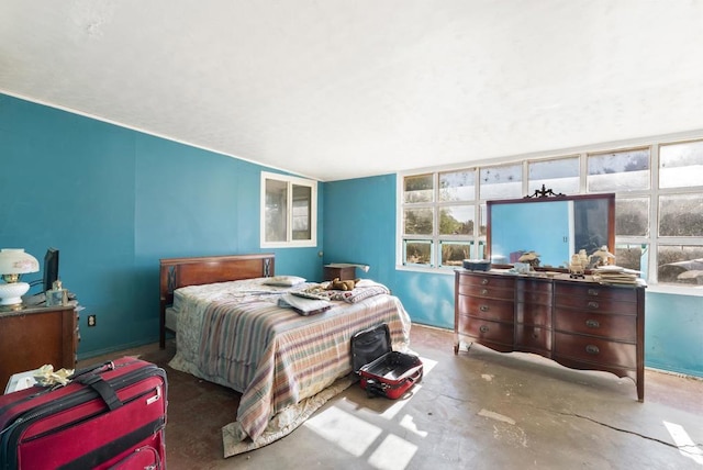 bedroom featuring concrete floors and multiple windows