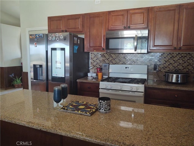 9373 Nevada Rd, Phelan, CA 92371 - kitchen featuring stainless steel appliances, light stone counters, backsplash, and brown cabinets