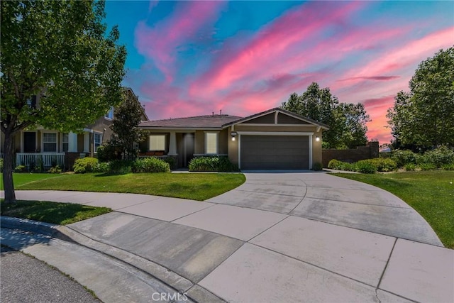 ranch-style house with a garage, stucco siding, a lawn, and driveway