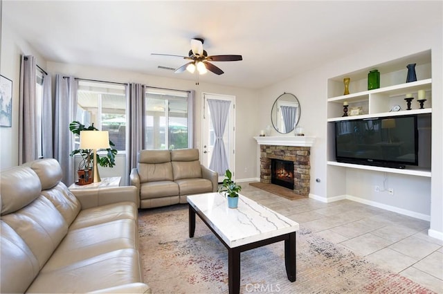 living room with visible vents, a stone fireplace, baseboards, a ceiling fan, and light tile patterned floors