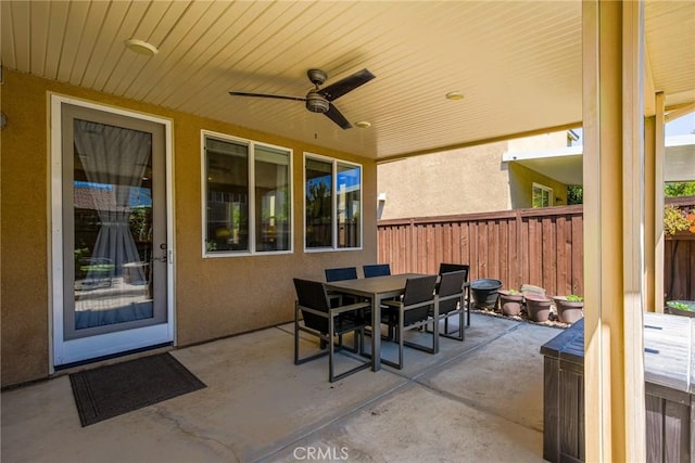 view of patio with a fenced backyard, a ceiling fan, and outdoor dining space