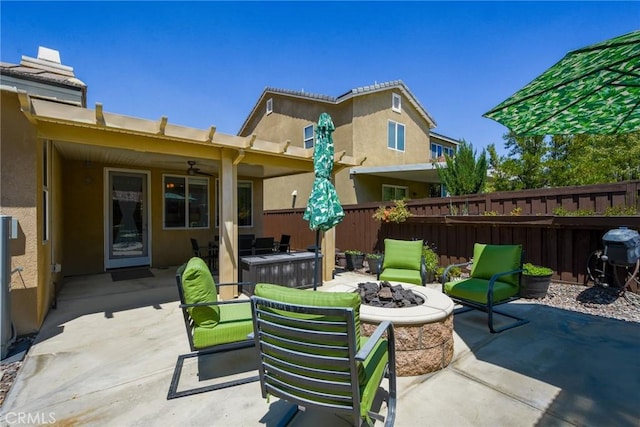 view of patio / terrace featuring fence, ceiling fan, and an outdoor fire pit