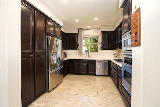 kitchen featuring dark brown cabinets, recessed lighting, light countertops, light tile patterned floors, and stainless steel appliances