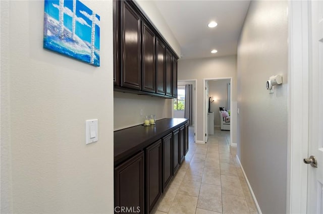 hallway featuring recessed lighting, baseboards, and light tile patterned floors