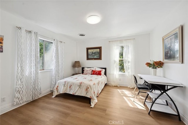 318 E 11th St, Pomona, CA 91766 - bedroom featuring baseboards, light wood finished floors, multiple windows, and visible vents