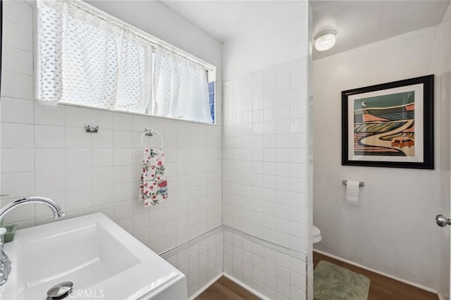 318 E 11th St, Pomona, CA 91766 - bathroom with tile walls, wood finished floors, a sink, and toilet