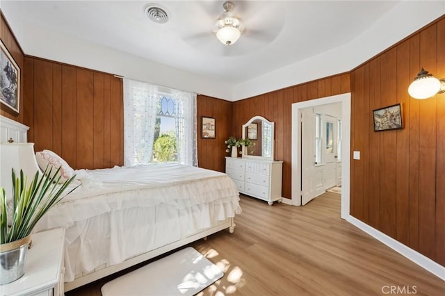 318 E 11th St, Pomona, CA 91766 - bedroom with visible vents, baseboards, wood finished floors, ceiling fan, and wooden walls