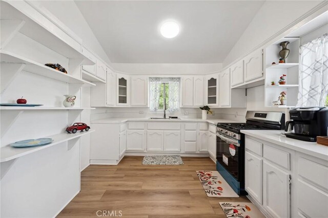 318 E 11th St, Pomona, CA 91766 - kitchen featuring open shelves, vaulted ceiling, gas stove, and white cabinetry