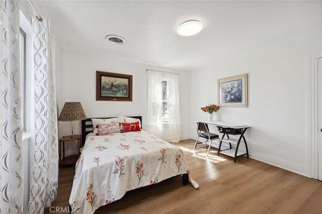 318 E 11th St, Pomona, CA 91766 - bedroom with visible vents, baseboards, and wood finished floors