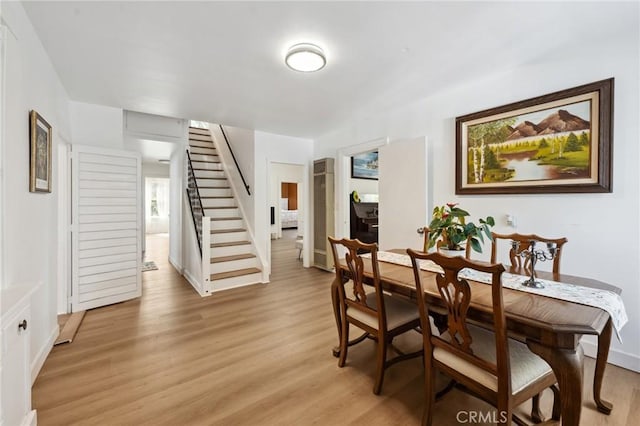 318 E 11th St, Pomona, CA 91766 - dining space with light wood-type flooring, baseboards, and stairway