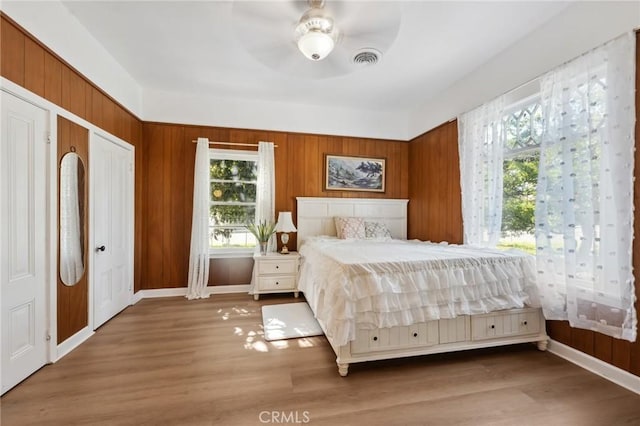 318 E 11th St, Pomona, CA 91766 - bedroom featuring wooden walls, multiple windows, wood finished floors, and visible vents