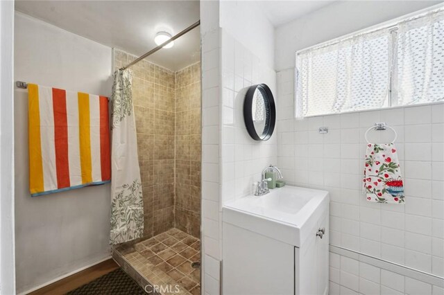 318 E 11th St, Pomona, CA 91766 - full bath featuring a tile shower, vanity, and tile walls