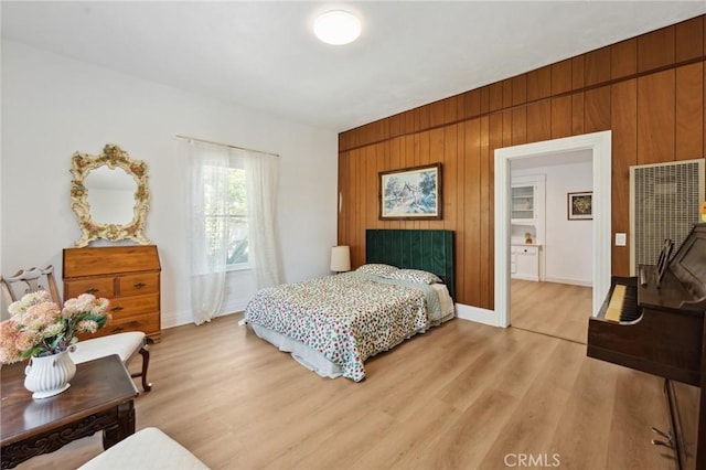 318 E 11th St, Pomona, CA 91766 - bedroom with light wood-type flooring, baseboards, and wood walls