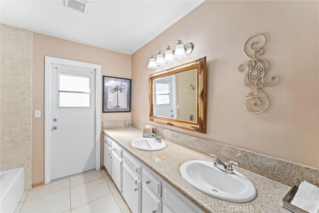 bathroom with tile patterned flooring, a sink, visible vents, and double vanity