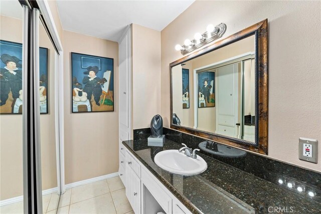 bathroom featuring vanity, tile patterned flooring, and baseboards
